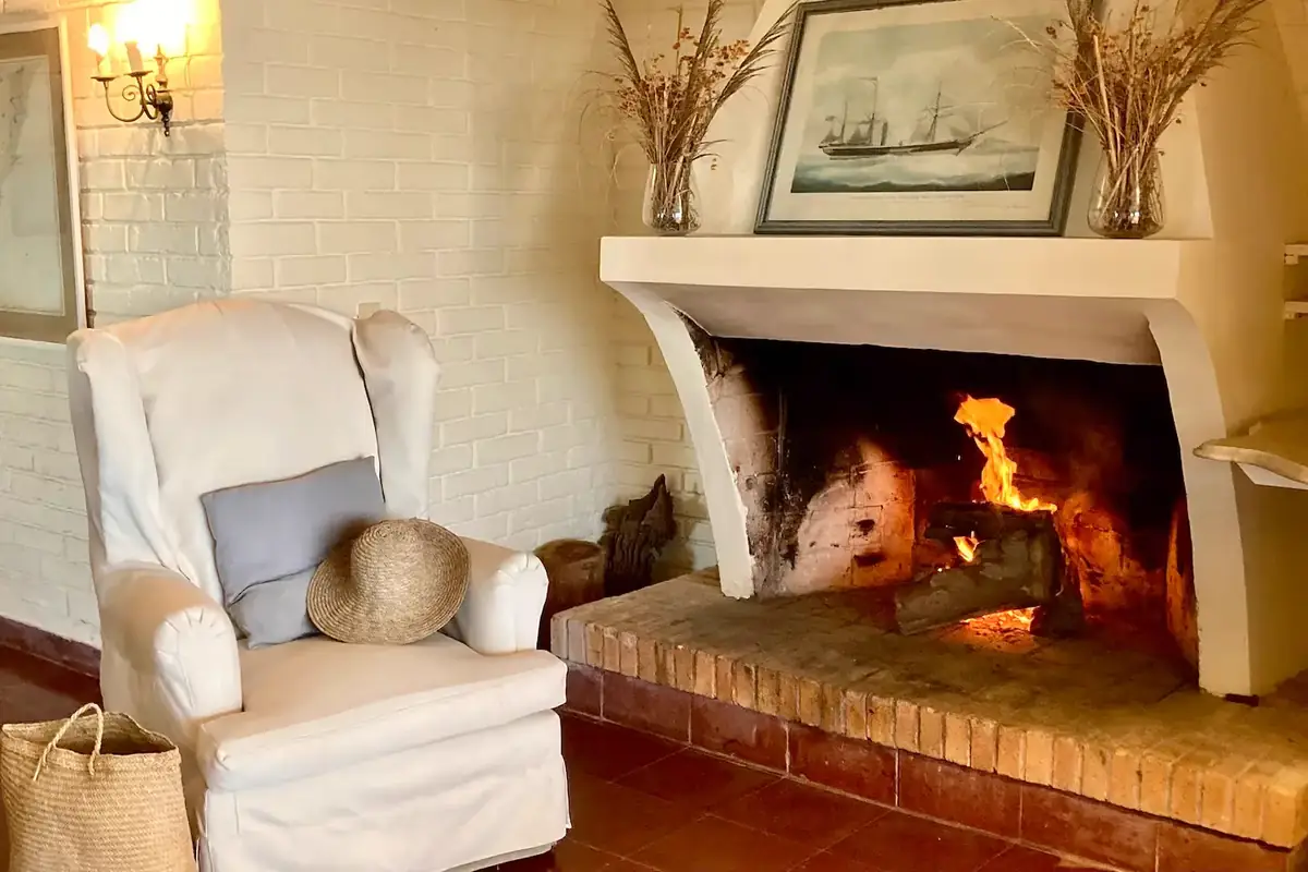 Salón con chimenea a leña y sillones de lectura