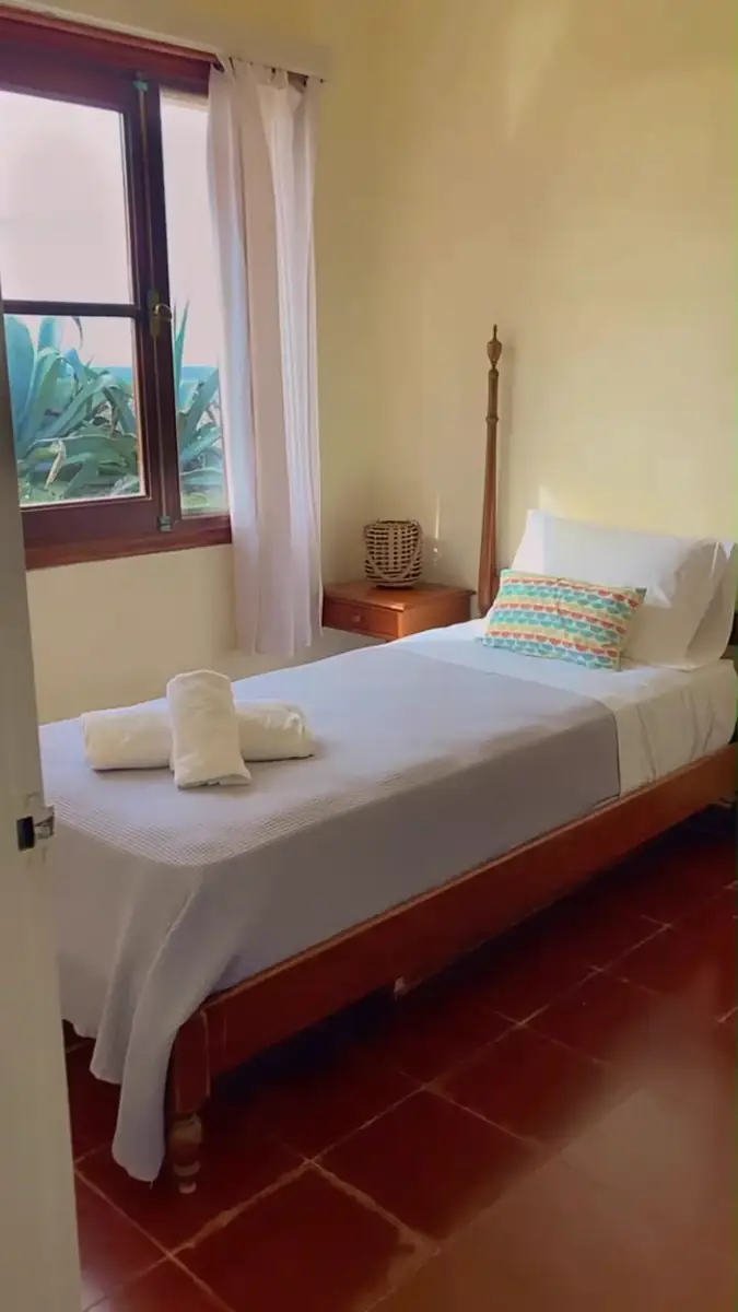 Dormitorio minimalista con cama individual y madera clara