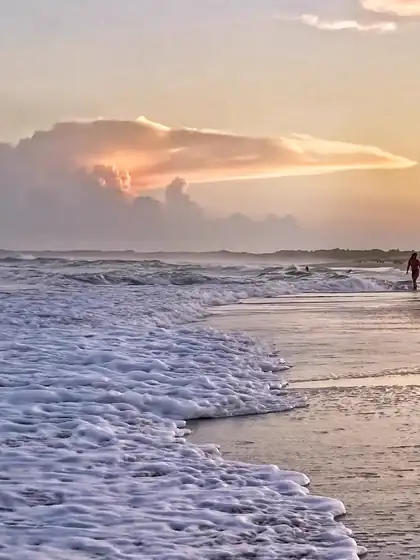 Espuma de las olas en la orilla bajo un cielo de atardecer